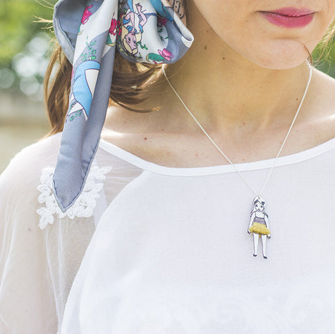 Colette-silver doll necklace with tutu on a white top